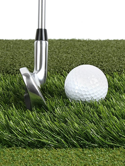 a golf club in front of a golf ball in the long grass of the Orlimar Triple Surface Golf Hitting Mat