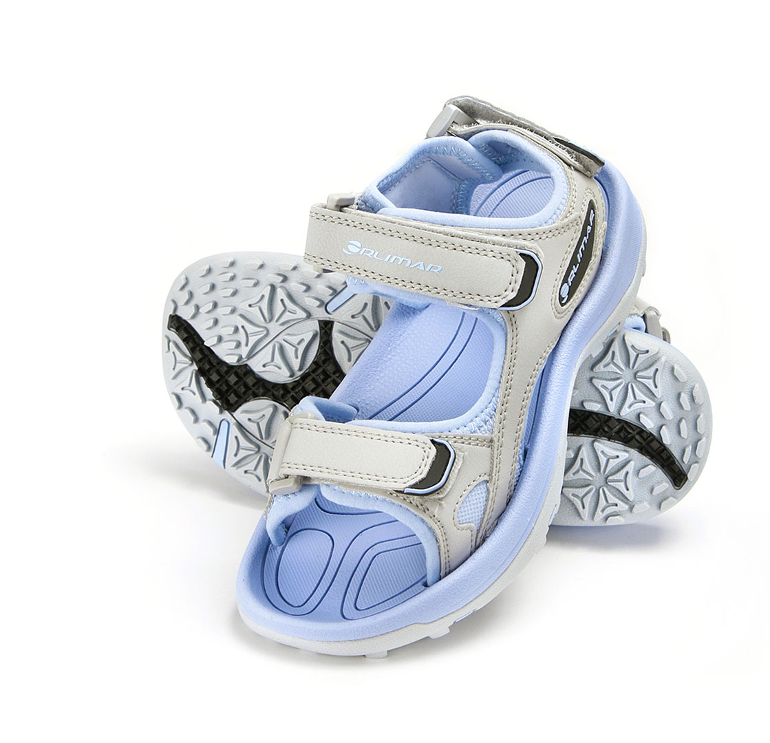 top of left Orlimar spikeless women's golf sandal leaning against the matching right sandal showing the sole