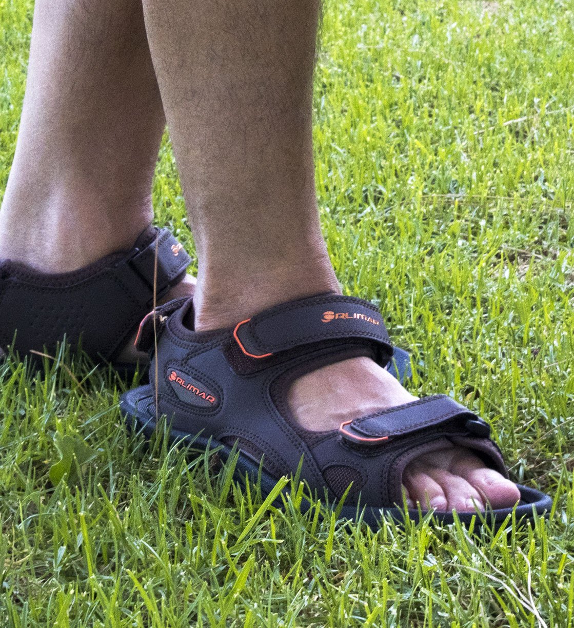 someone wearing Orlimar's men's spikeless golf sandals in the rough