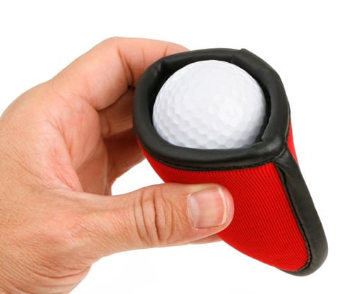 person's hand holding a Intech Squeaky Clean Pocket Golf Ball Washers with a golf ball inside